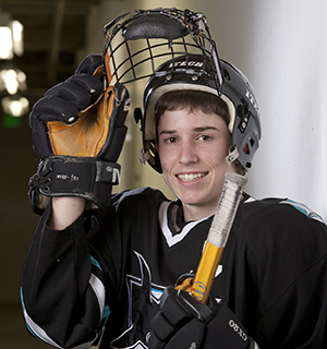Teenage boy wearing protective gear for hockey.