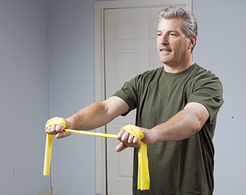 Man using resistance band to strengthen his shoulders and arms