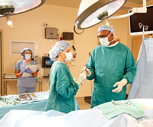 Healthcare providers performing surgery in operating room.