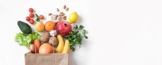 Paper grocery bag full of colorful vegetables and fruits