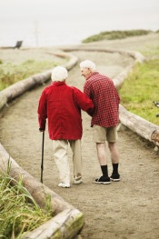 Pareja de ancianos caminando sobre una ruta